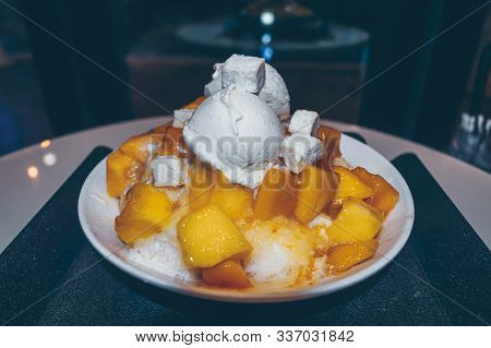 Close Up View Of Freshly Made Bowl Of Mango Bingsoo - Korean Shaved Ice Dessert With Sweet Toppings