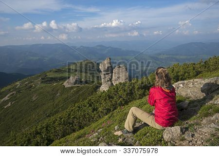 Girl In Bright Clothes Contemplates Mountains