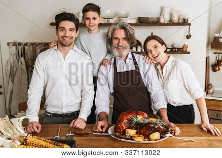 Smiling big family celebraring Christmas together, standing at the kitchen table