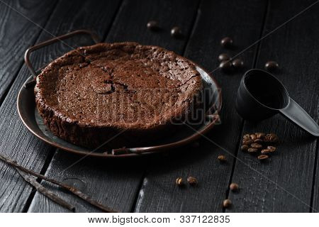 Homemade Chocolate Cake Kladdkaka In Vintage Dish With Coffee Beans And Vanilla Pods On Black Backgr