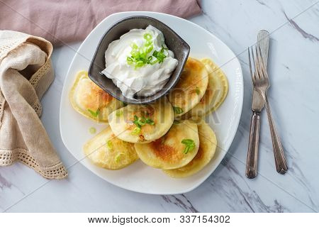 Delicious Authentic Polish Pierogies With Chopped Green Onion And Sour Cream
