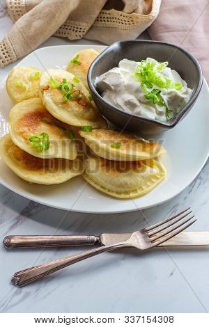 Delicious Authentic Polish Pierogies With Chopped Green Onion And Sour Cream