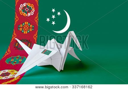 Turkmenistan Flag Depicted On Paper Origami Crane Wing. Handmade Arts Concept