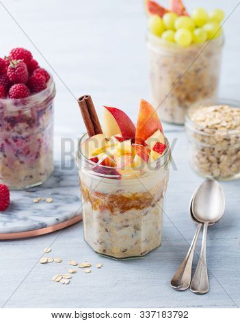 Overnight Oats, Bircher Muesli With Raspberry, Apple In Glass Jars On Wooden Background.