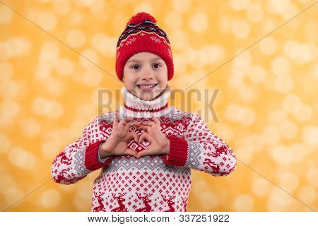 Little Girl In Winter Look Sputting Her Fingers In A Heart Shape
