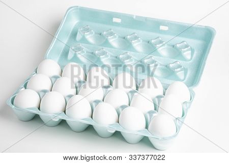 A Close-up Shot Of A Bright Green Styrofoam Crate Full Of White Eggs Set On A White Background.