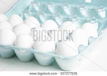 A Close-up Shot Of A Bright Green Styrofoam Crate Full Of White Eggs Set On A White Background.