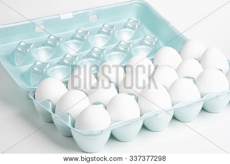 A Close-up Shot Of A Bright Green Styrofoam Crate Full Of White Eggs Set On A White Background.
