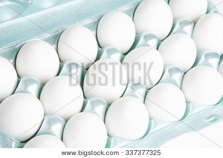 A Close-up Shot Of A Bright Green Styrofoam Crate Full Of White Eggs Set On A White Background.