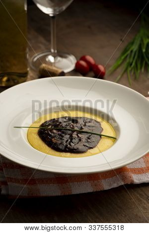 Cooked Corn Meal With Funghi Sauce On White Plate.