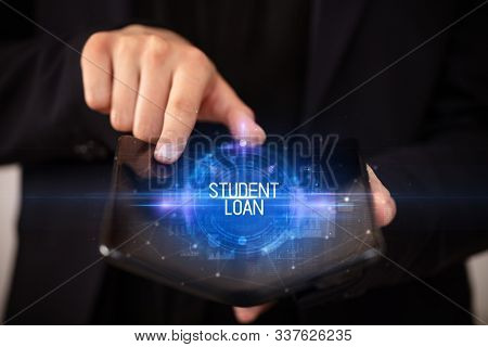 Young man holding a foldable smartphone with STUDENT LOAN inscription, educational concept