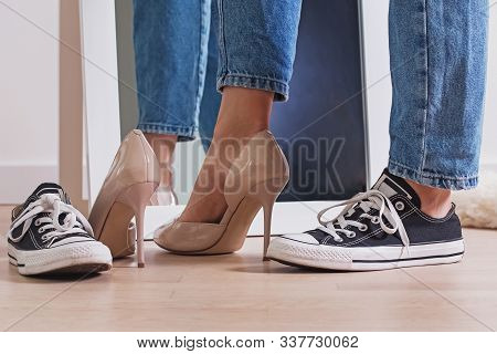 Closeup Of Woman Legs And Feet Wearing Two Different Shoes High Heels And Flat Sneakers