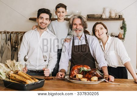 Smiling big family celebraring Christmas together, standing at the kitchen table