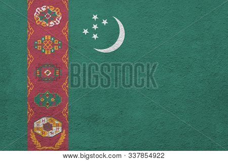 Turkmenistan Flag Depicted In Bright Paint Colors On Old Relief Plastering Wall. Textured Banner On 