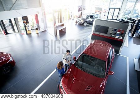 Car Dealer Presenting Vehicle To The Customer.