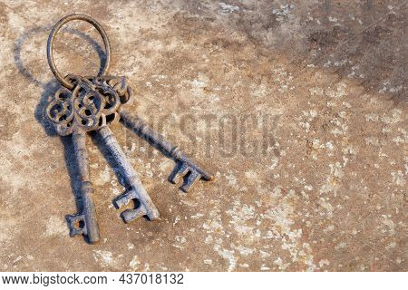 Old Rusty Key On Grunge Background. Vintage Door Keys. Antique Keys On Weathered Rusty Background. A