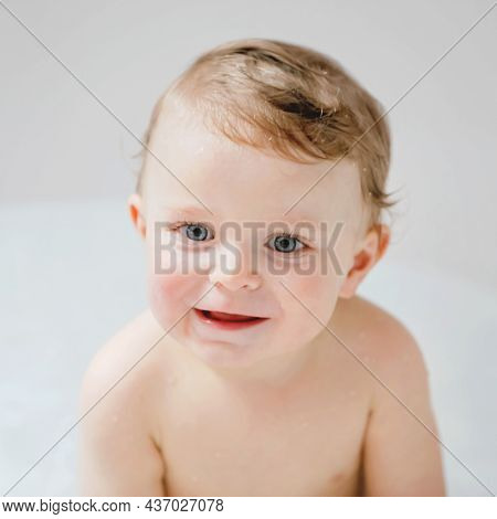 Cute Adorable Baby Child Taking Bath In Bathtub At Home. Happy Healthy Boy Or Girl Playing, Splashin