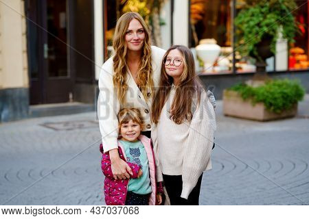 Young Mother, School Preteen Girl And Preschool Child Making Walk In The City. Happy Family, Woman A