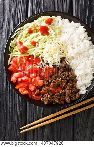 Takoraisu Okinawan Taco Rice With Ground Beef, Vegetables, Cheese And Sauce Close-up In A Bowl On Th