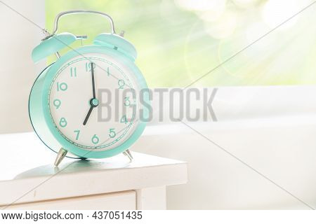 Circadian Rhythms Concept - Alarm Clock Set On 7 Am With Sun Rays