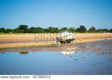 A Motorboat Laying On The Beach At Lowtide On A Sunny Summertime On The Isle Of île De Re In The Cha