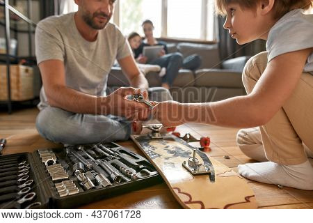 Crop Close Up Of Caucasian Father Repair Skateboard With Small Teen Son Use Tools Utensils. Dad And 