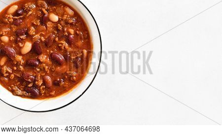 Close Up View Of Cowboy Beans With Ground Beef, Jalapeno Pepper And Bacon In Bowl Over Light Stone B