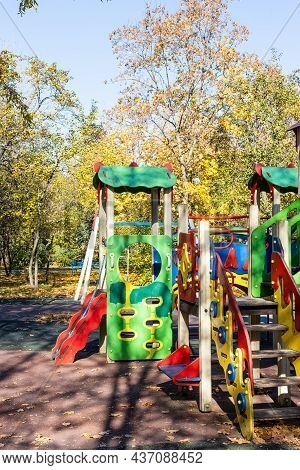 Colorful Wooden Rides, Slides And Houses On Children's Playground In Public City Park On Sunny Autum
