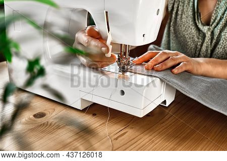 Seamstress Sewing The Linen Fabric On The Sewing Machine In Small Studio. Fashion Atelier, Tailoring
