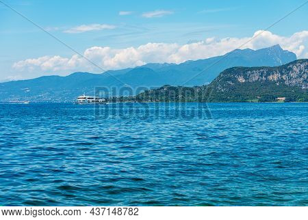 White Ferry Boat In Navigation On Lake Garda (lago Di Garda), On Background The Promontory Of San Vi