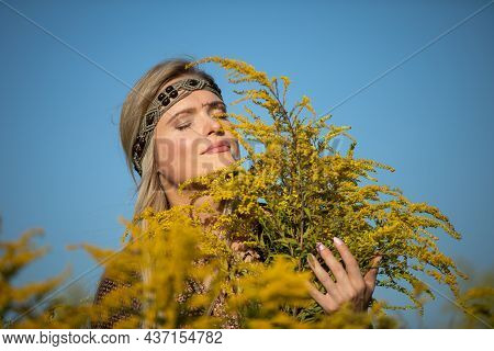 A Young Herbalist Delights In The Scent Of Goldenrod Flowers.