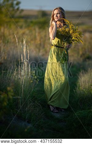 A Young Herbalist In Love With A Bouquet Of Herbs Strolls Romantically Through The Meadows.