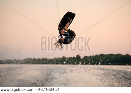 Male Wakeboarder Makes Dangerous Stunts Jumping And Flips On Wakeboard Over Splashing Wave