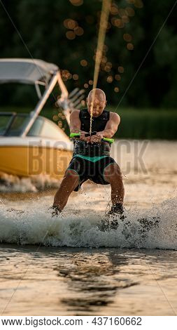 Front View Of Energetic Man Holding A Rope And Wakeboarding On The Water