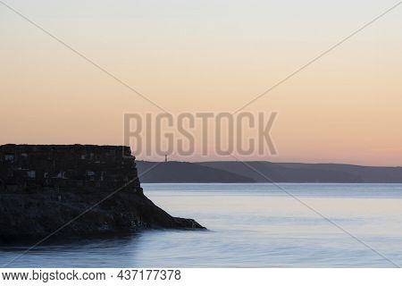 Beautiful Sunrise Over Pentewan Sands In Cornwall With Pastel Sky And Long Exposure Ocean