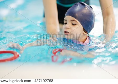 Preschool Swim Lessons For Kids Theme. Child Pick Up Ring In Swimming Pool
