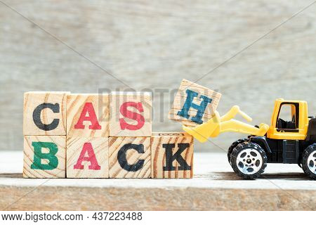 Toy Bulldozer Hold Letter Block H, K In Word Cash Backon Wood Background