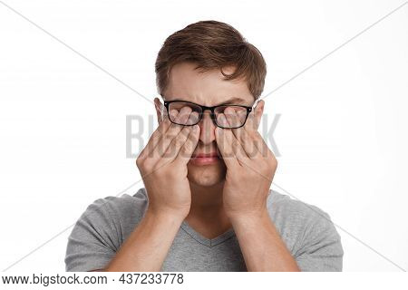 Millennial Caucasian Guy In Glasses Rubs Eyes, Suffers From Dryness, Isolated On White Background. I