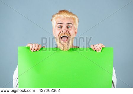 Portrait Of Excited Man Showing Blank Signboard With Copyspace Area For Slogan Or Text. Young Funny 