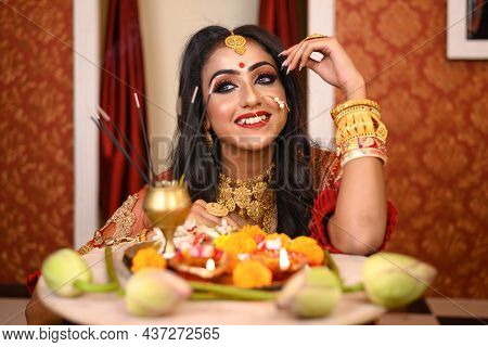 Portrait Of Pretty Young Indian Woman Wearing Traditional Saree, Gold Jewellery And Bangles, Smiles 