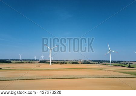 Windmill Among Agricultural Fields. Wind Turbine Generator At Summer Day. Wind Energy Concept. Suist