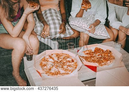 Friends eating pizza, hanging out at a sleepover party