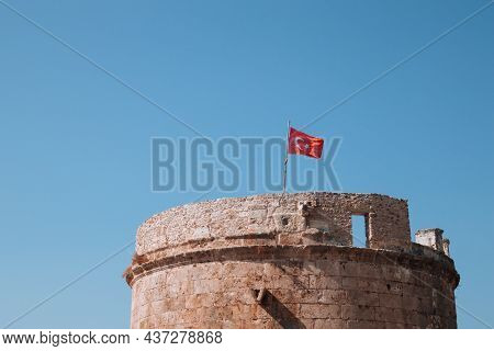Stone Fortress And Turkish Flag In The Old Town Of Kaleici. Hidirlik Tower In Antalya, Turkey