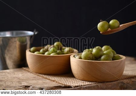 Wild Indian Gooseberry Or Amla In A Bowl With Spoon On Black Background, Fruit Tree In Asia Use In V