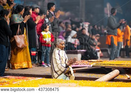 17.12.2019, Varanasi, India. The Sacred Religious Ceremony Of Arati. An Old Woman Stands Praying And