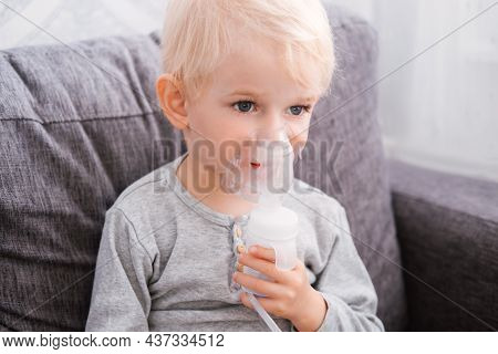 Close Up Portrait Of Cute Little Blond Boy Does Inhalation At Home.