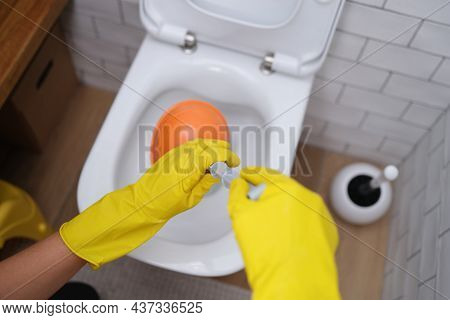 Hands In Gloves Hold A Plunger At The Toilet, Close-up
