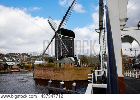 Cityscape Of Leiden, The Netherlands. View Of New Rhine River And Dutch Houses And Traditional Windm