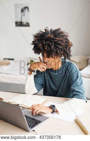 Vertical Portrait Of African-american Teenage Boy Using Laptop While Studying At Home Or In College 