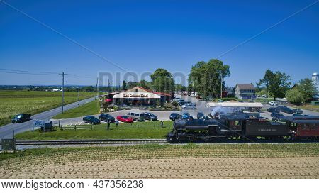 Ronks, Pennsylvania, June 2021 - Aerial View Of A Steam Train Puffing Smoke And Steam Passing People